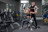 Femme sportive aidée par un coach homme en salle de sport